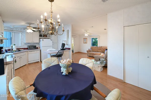 a dining room with furniture a chandelier a glass table and chairs