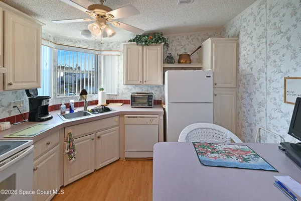 a kitchen with a refrigerator a sink dishwasher and cabinets