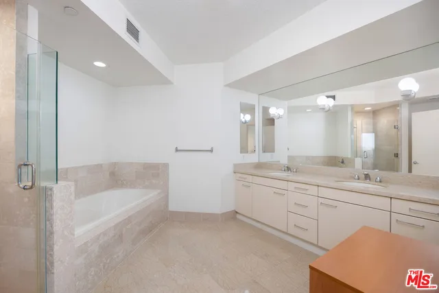 a spacious bathroom with a bathtub sink and mirror
