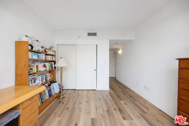 a view of a hallway with wooden floor and closet