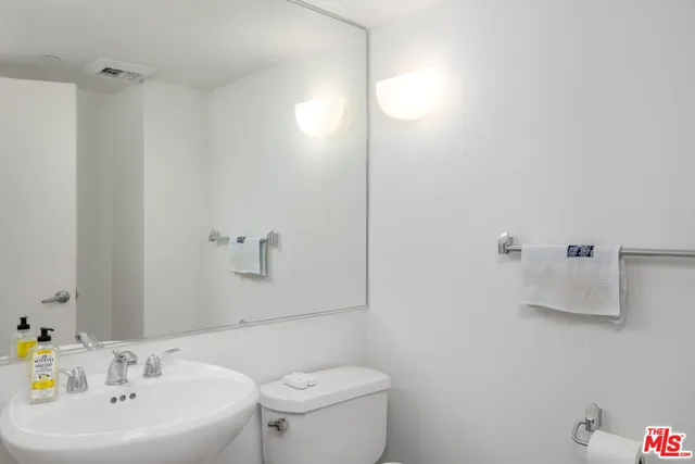 a bathroom with a sink a toilet and mirror