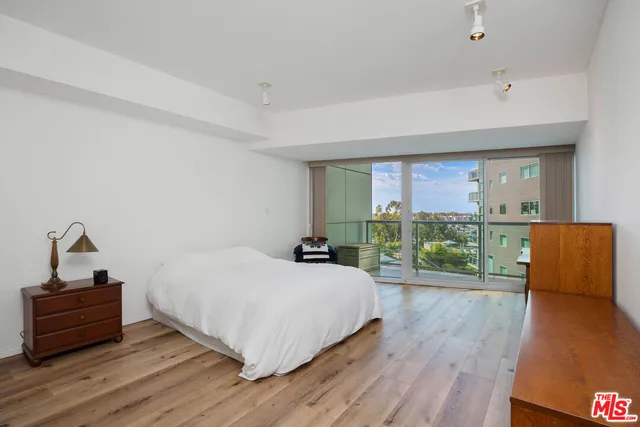 a bedroom with a bed and a wooden floor