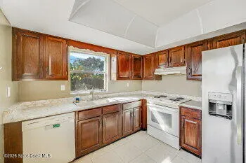 a kitchen with stainless steel appliances granite countertop a refrigerator stove and sink