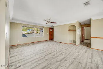 a view of empty room with wooden floor and windows