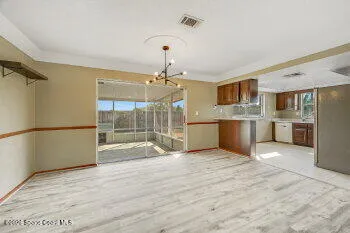 a view of a kitchen with wooden floor a sink a refrigerator and window