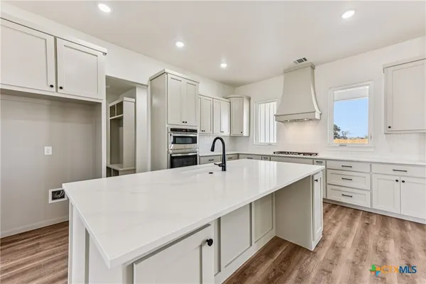 a kitchen with kitchen island a sink stainless steel appliances and cabinets