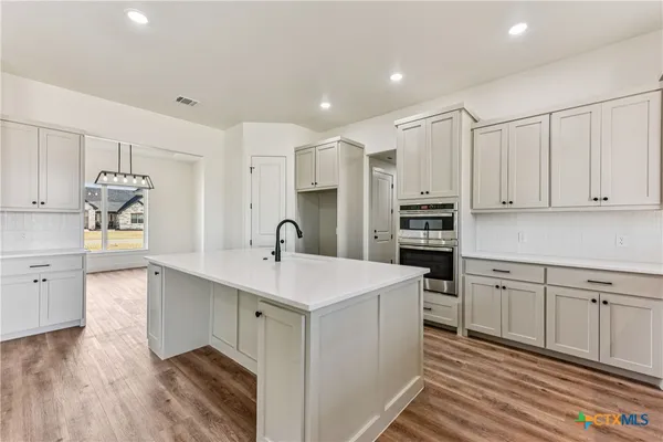a kitchen with kitchen island a sink stainless steel appliances and cabinets