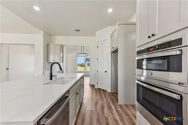 a kitchen with a sink stainless steel appliances and cabinets