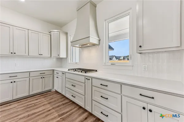 a kitchen with granite countertop white cabinets and white appliances