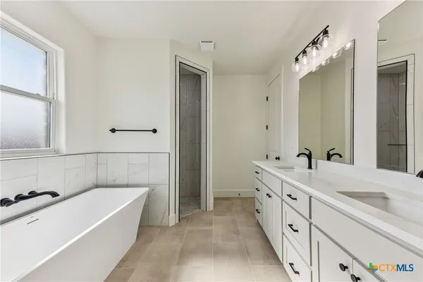 a bathroom with a tub sink and mirror
