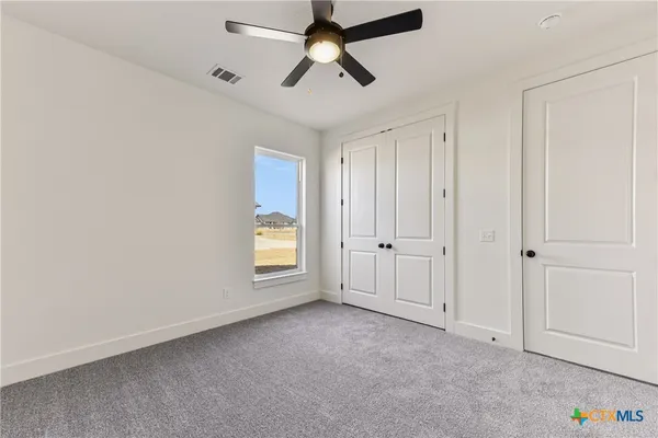 an empty room with chandelier fan