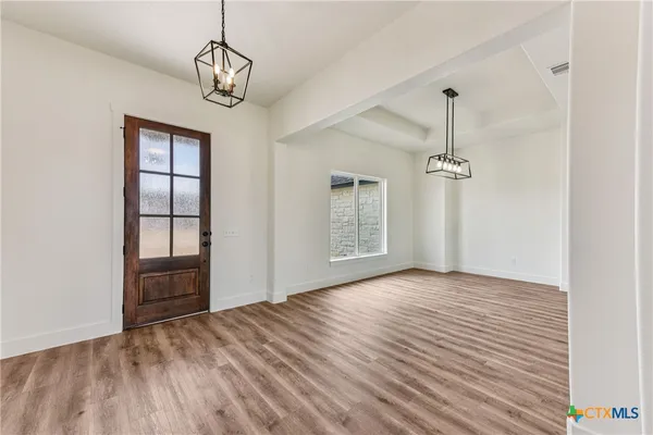 a view of empty room with wooden floor and window