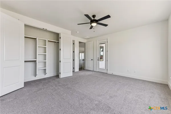 a view of a livingroom with a ceiling fan & entryway