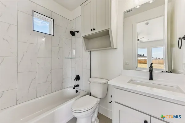 a bathroom with a granite countertop toilet a sink and a bathtub