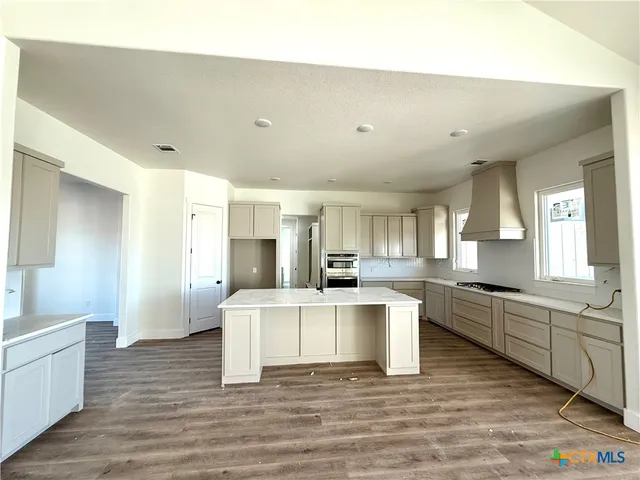 a large white kitchen with cabinets a sink and appliances