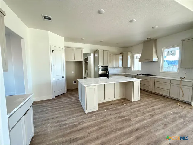 a kitchen with white cabinets and white appliances