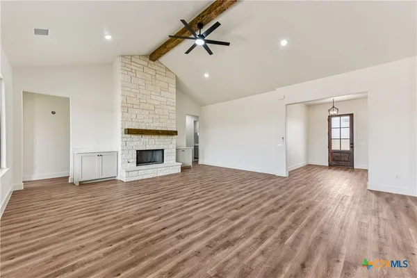 a view of empty room with wooden floor and fireplace