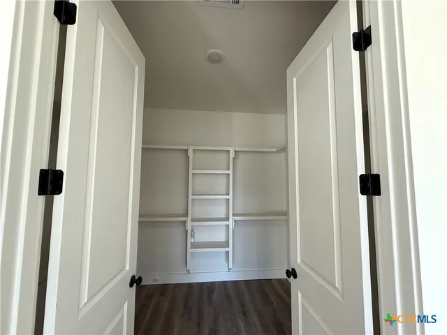 a view of walk in closet with empty racks
