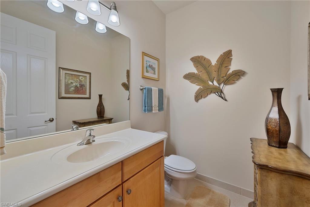 6529 Marbella Drive Naples, FL 34105 - Photo 11 of 29 a bathroom with a toilet a sink and mirror