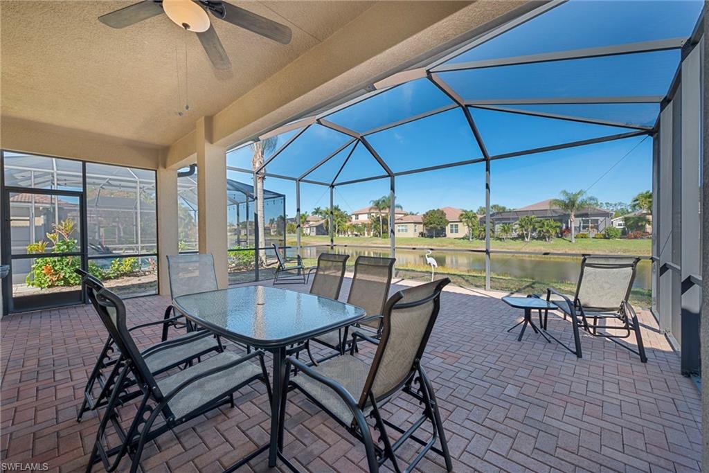 6529 Marbella Drive Naples, FL 34105 - Photo 14 of 29 a view of a patio with table and chairs under an umbrella