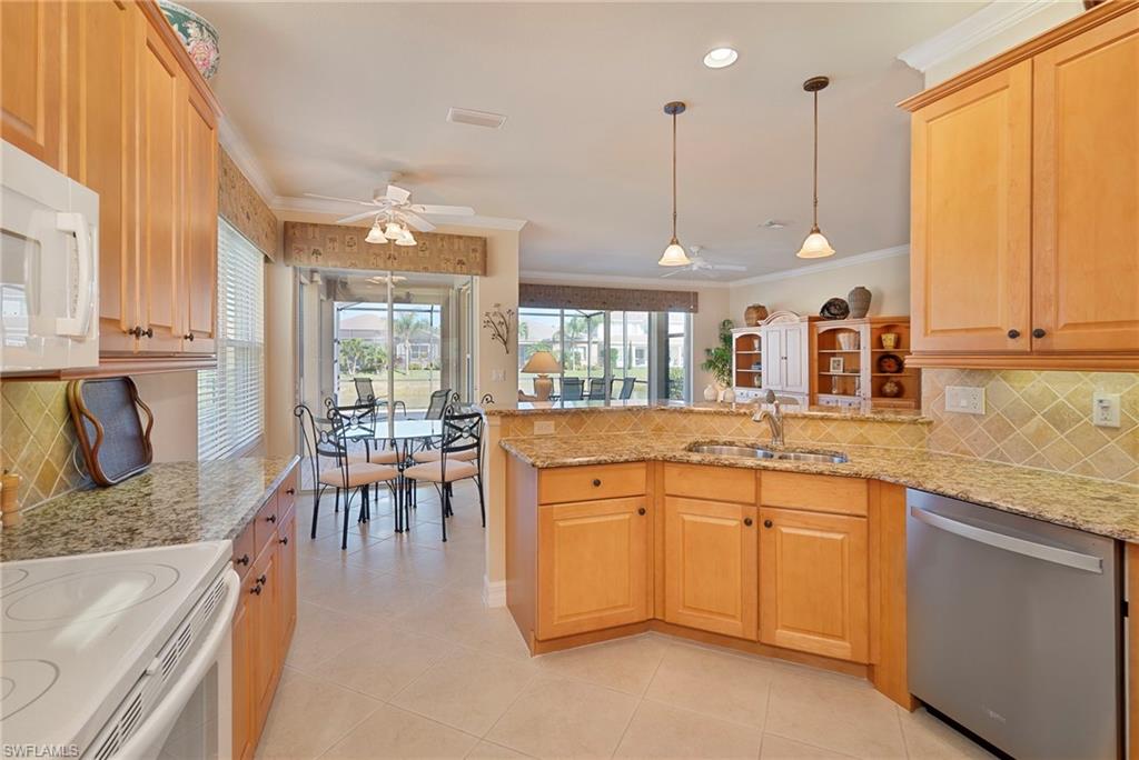 6529 Marbella Drive Naples, FL 34105 - Photo 5 of 29 a large kitchen with lots of counter top space and dining table