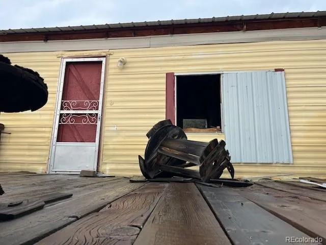 a view of a porch with chairs and potted plants