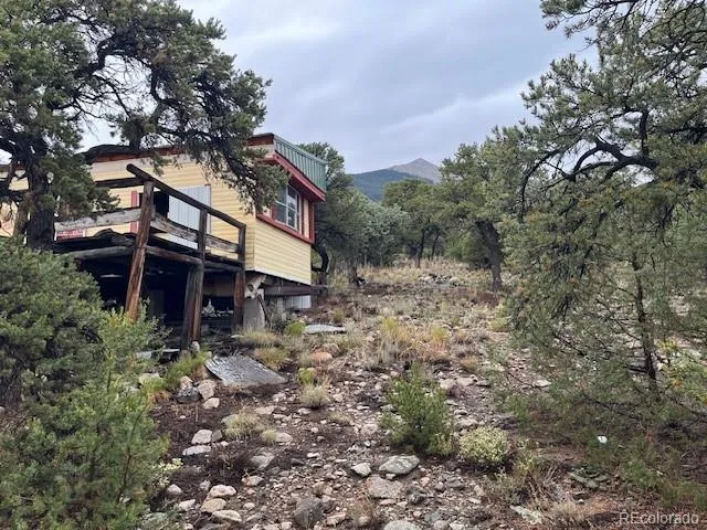 a view of a house with a tree and wooden fence