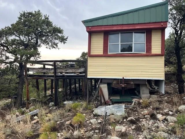a small wooden house with a large window and wooden fence