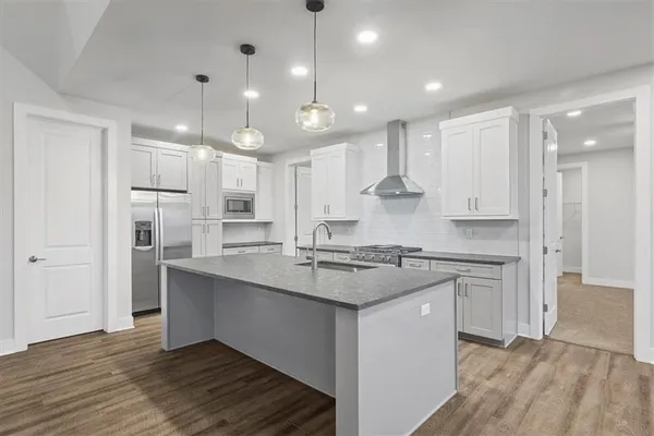 a kitchen with kitchen island a sink stainless steel appliances and cabinets