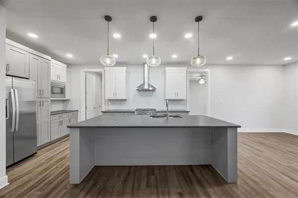 a kitchen with kitchen island a sink appliances and cabinets
