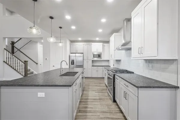 a kitchen with stainless steel appliances granite countertop a sink a stove and a granite counter tops