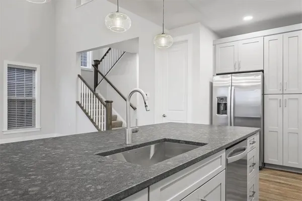 a kitchen with stainless steel appliances granite countertop a sink a refrigerator and a granite counter tops
