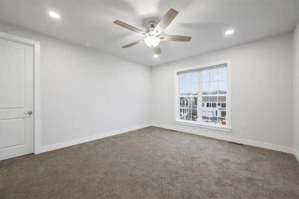 an empty room with fan and windows