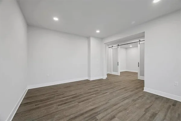 a view of an empty room with wooden floor