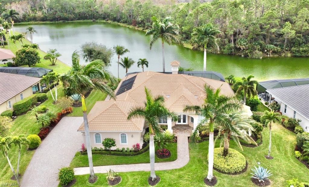 an aerial view of a house with a yard and lake view