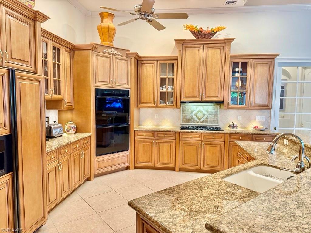 8064 Tiger Lily Drive Naples, FL 34113 - Photo 11 of 21 a kitchen with granite countertop a sink and cabinets
