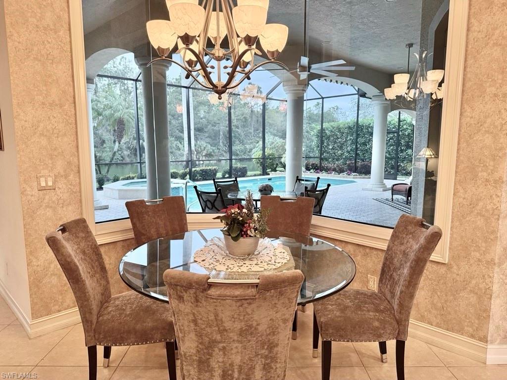 8064 Tiger Lily Drive Naples, FL 34113 - Photo 12 of 21 a dining room with furniture a chandelier and wooden floor