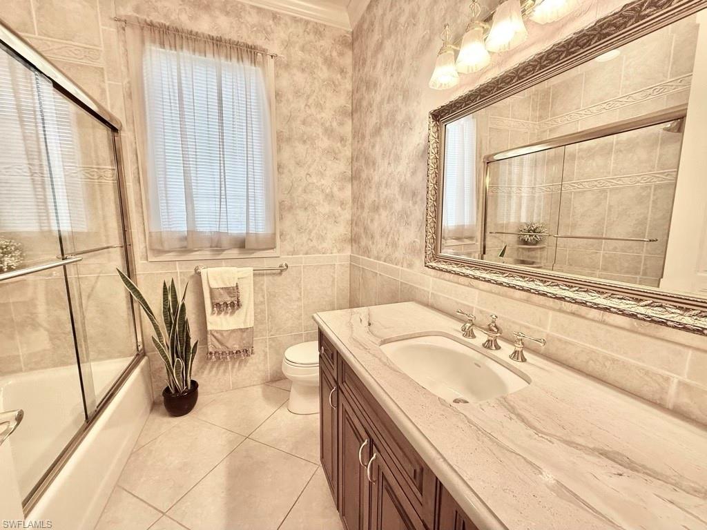 8064 Tiger Lily Drive Naples, FL 34113 - Photo 14 of 21 a bathroom with a granite countertop sink a mirror and a bathtub