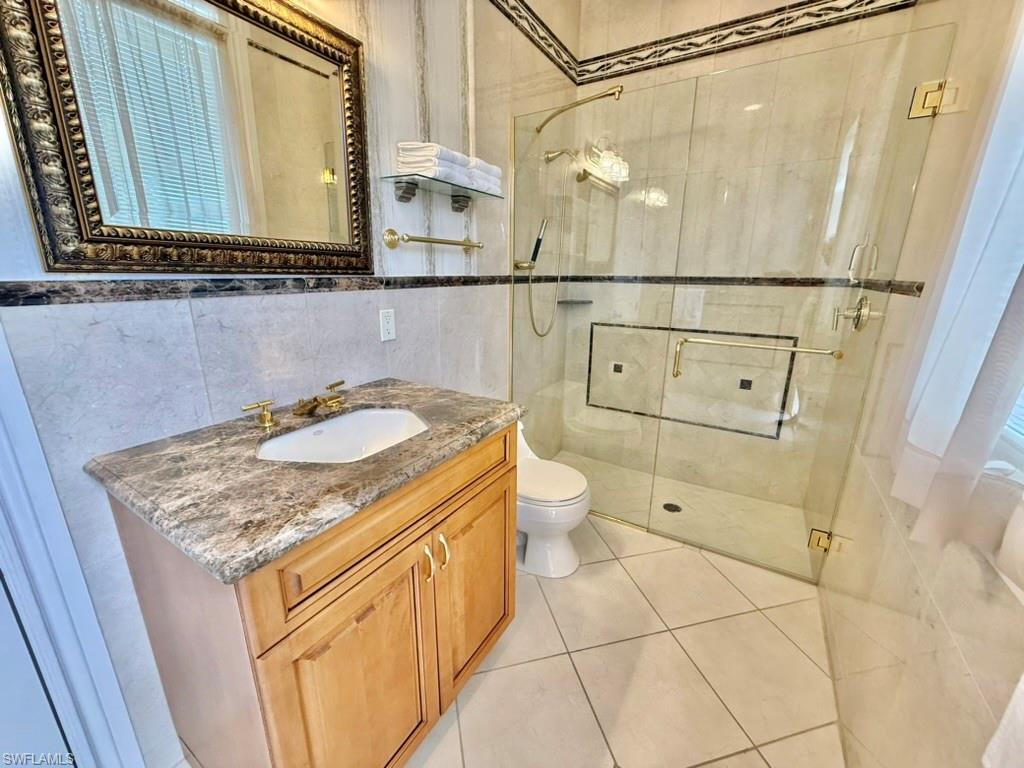 8064 Tiger Lily Drive Naples, FL 34113 - Photo 21 of 21 a bathroom with a sink a toilet and shower