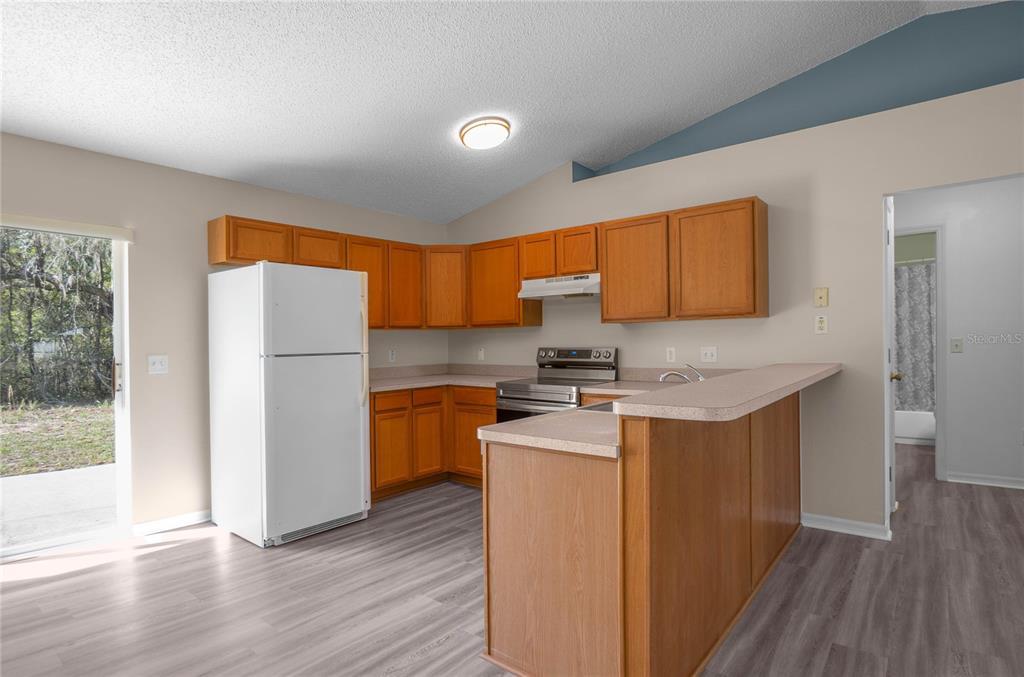 3926 East Bennett Street Inverness, FL 34453 - Photo 12 of 33 a kitchen with stainless steel appliances granite countertop a refrigerator a stove a sink and a microwave