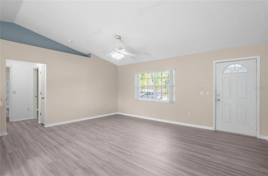 3926 East Bennett Street Inverness, FL 34453 - Photo 7 of 33 an empty room with wooden floor and windows
