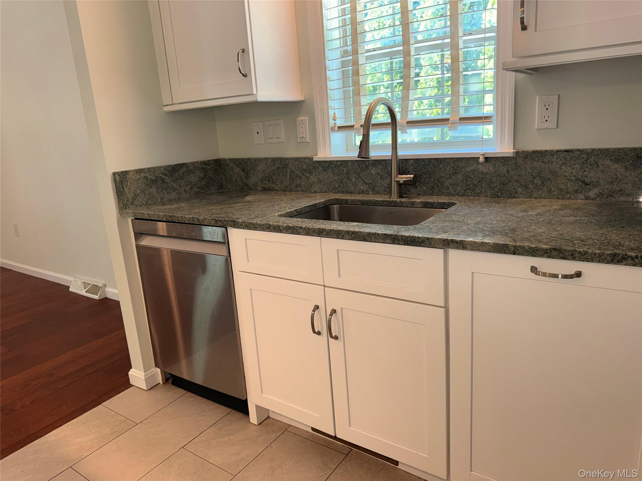 1661 Old Country Road, Unit 516 Riverhead, NY 11901 - Photo 18 of 50 a kitchen with granite countertop a sink and a window