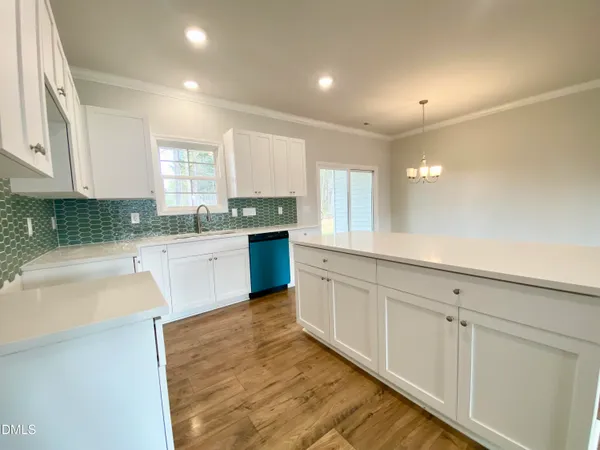 a kitchen with granite countertop a white sink and cabinets