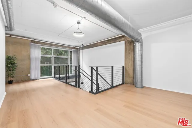 an empty room with windows and couches