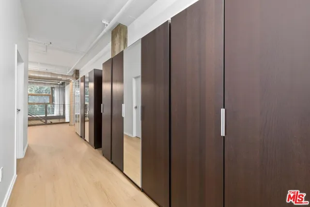 a view of a hallway with wooden shelves