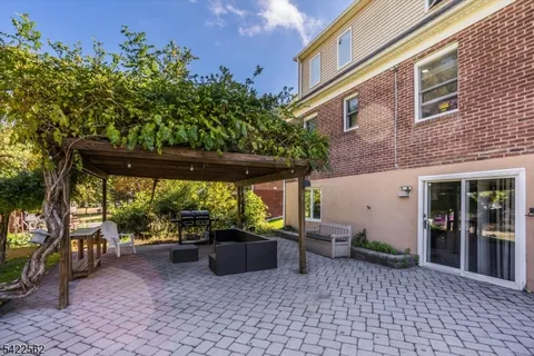a view of a patio with table and chairs potted plants and floor to ceiling window