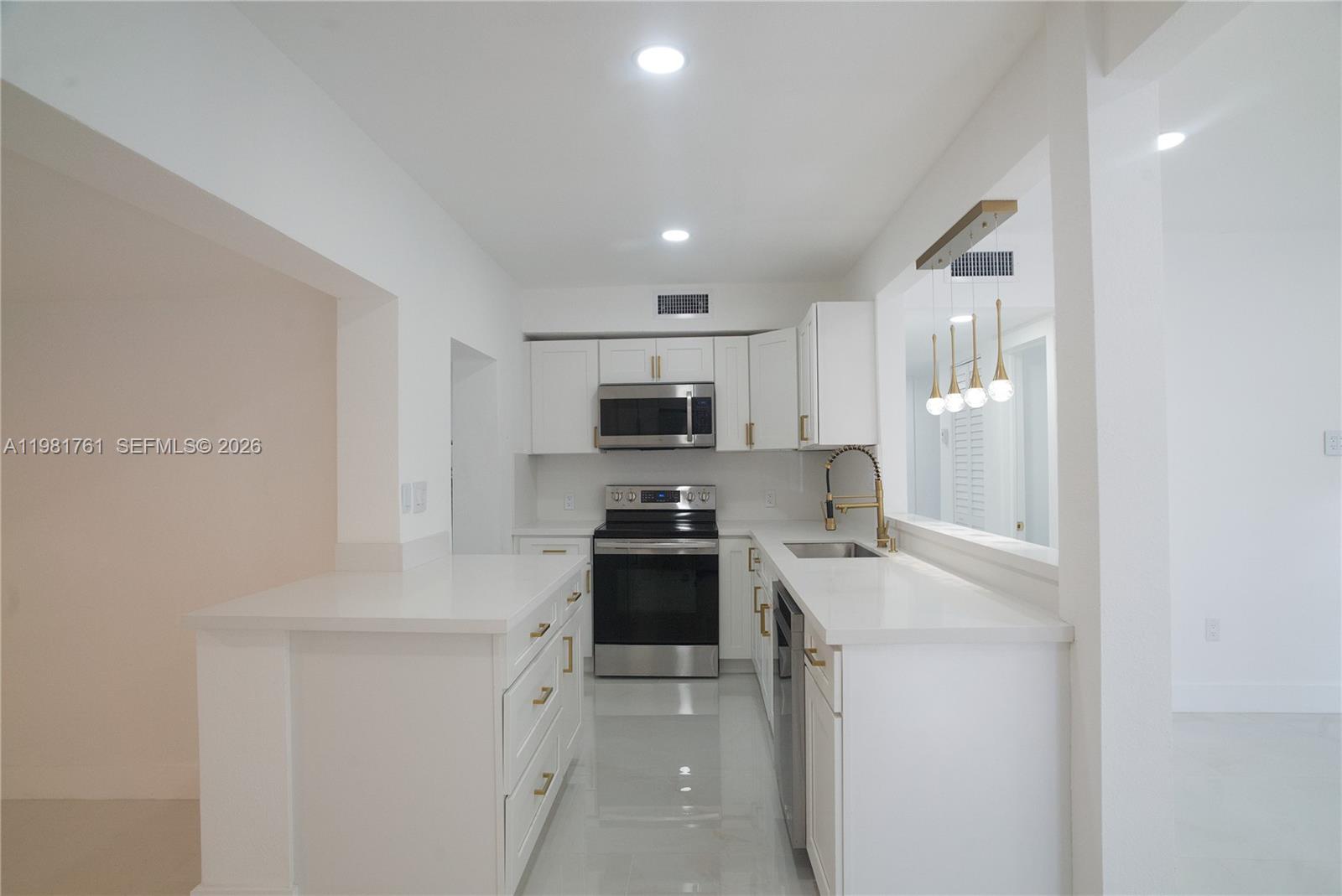 315 Northwest 127th Street North Miami, FL 33168 - Photo 20 of 67 a kitchen with stainless steel appliances a refrigerator sink and stove
