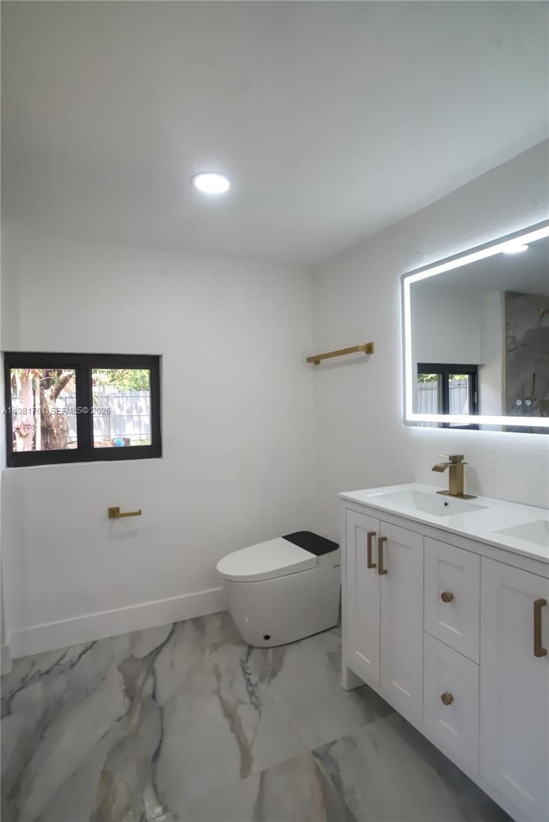 315 Northwest 127th Street North Miami, FL 33168 - Photo 44 of 67 a bathroom with a toilet a sink a mirror a window and vanity