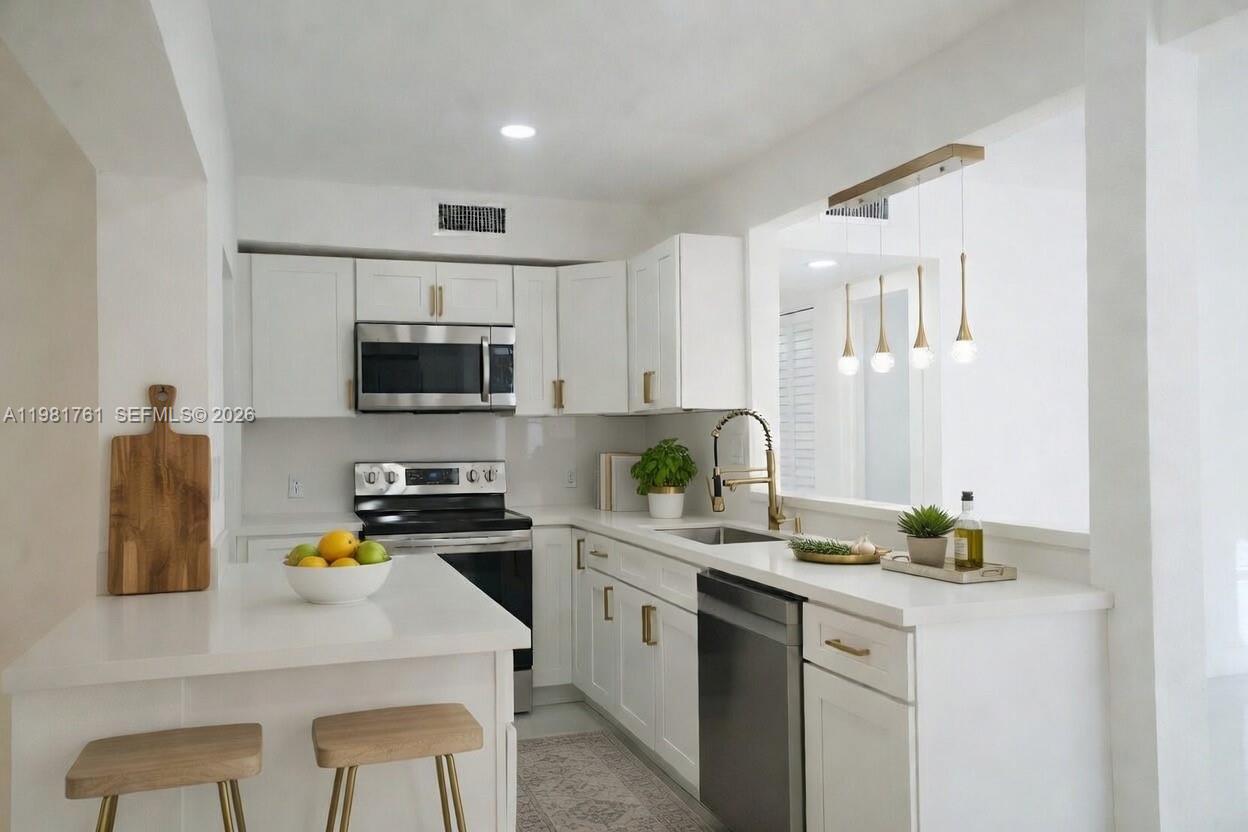 315 Northwest 127th Street North Miami, FL 33168 - Photo 8 of 67 a kitchen with a sink a stove and cabinets