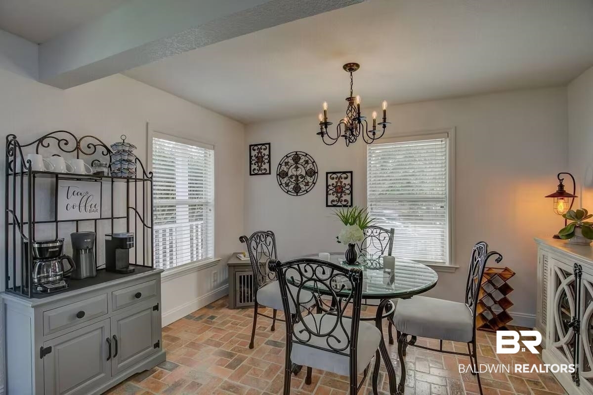 16297 Honey Road Summerdale, AL 36580 - Photo 14 of 24 Dining area featuring brick-finish flooring, a wrought iron chandelier, and white walls